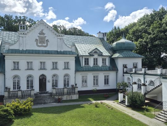 Zabytkowy, biały pałac w Adampolu otoczony zielenią, będący siedzibą szpitala chorób płuc.