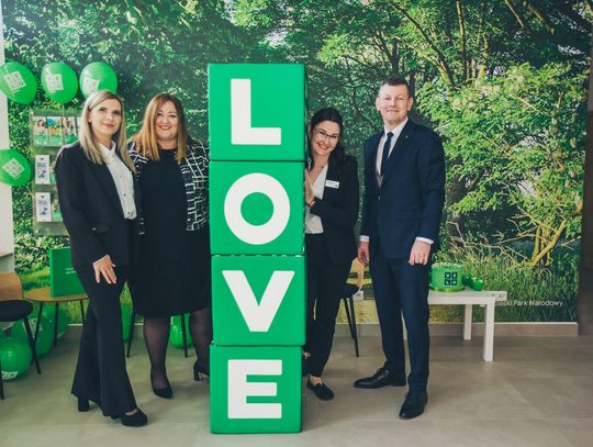 Nowoczesne i jasne wnętrze nowej placówki VeloBanku w Białej Podlaskiej. Widoczne stanowiska obsługi klienta z doradcami, logotypy VeloBank na ścianach oraz zielona roślinność w donicach. Profesjonalna, przyjazna przestrzeń bankowa przy ul. Gabriela Narutowicza 40.