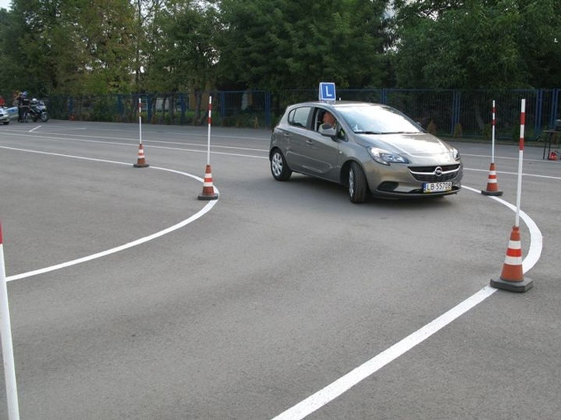 Egzamin na prawo jazdy bez „łuku”? Szykują się duże zmiany Szary samochód nauki jazdy marki Opel z eMką na dachu podczas manewru jazdy po łuku na placu manewrowym wyznaczonym pachołkami i tyczkami