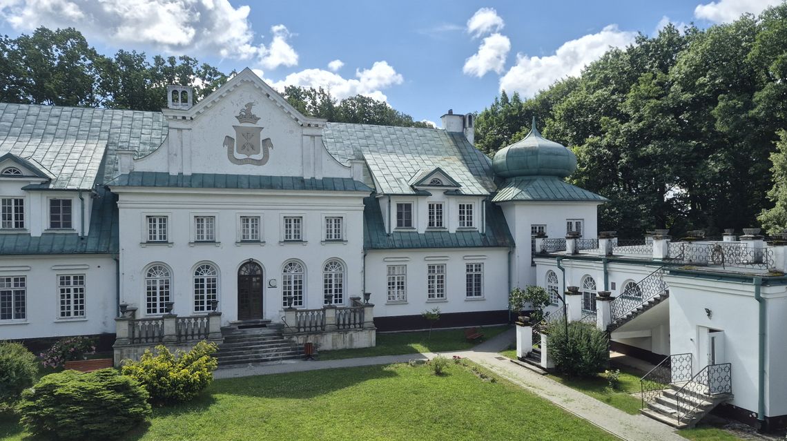 Zabytkowy, biały pałac w Adampolu otoczony zielenią, będący siedzibą szpitala chorób płuc.