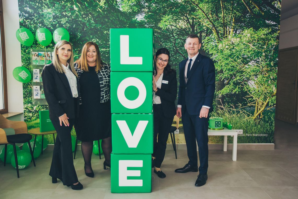 Nowoczesne i jasne wnętrze nowej placówki VeloBanku w Białej Podlaskiej. Widoczne stanowiska obsługi klienta z doradcami, logotypy VeloBank na ścianach oraz zielona roślinność w donicach. Profesjonalna, przyjazna przestrzeń bankowa przy ul. Gabriela Narutowicza 40.